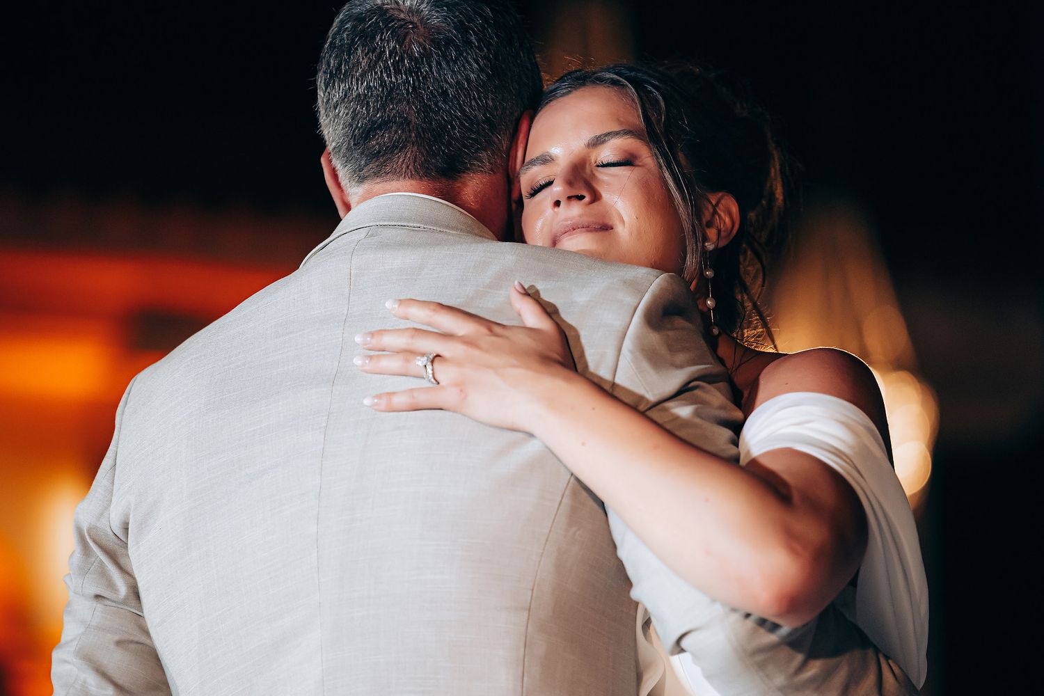 Intimate dance moment captured in dramatic lighting at an indoor wedding reception.