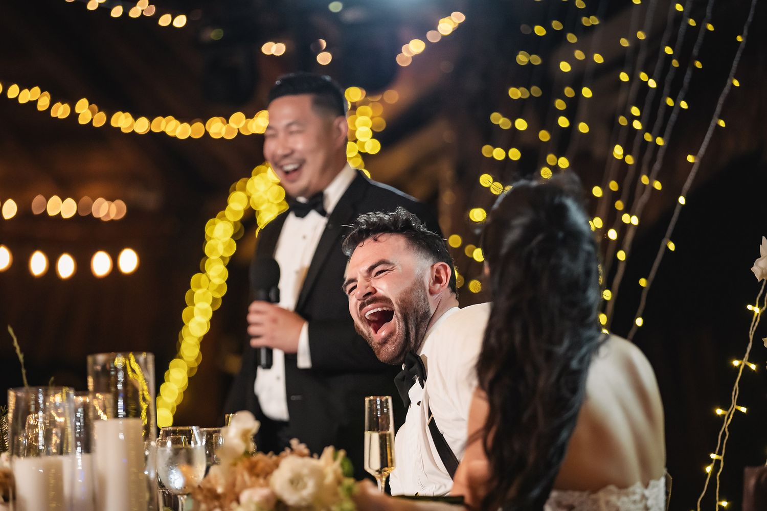 Wedding reception venue with festive lighting and guests enjoying the celebration.