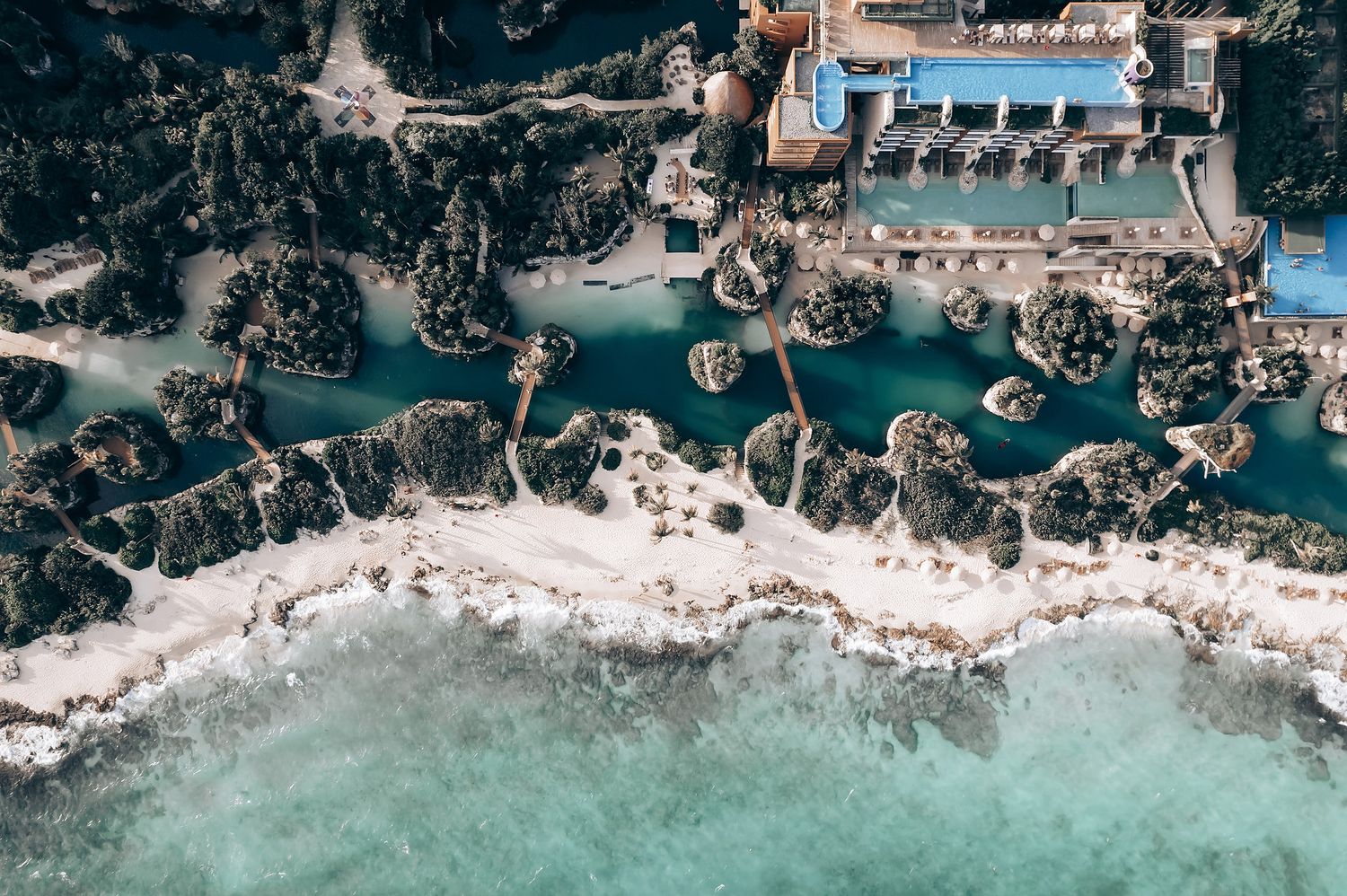 Aerial view of coastal venue with turquoise waters and rocky shoreline.