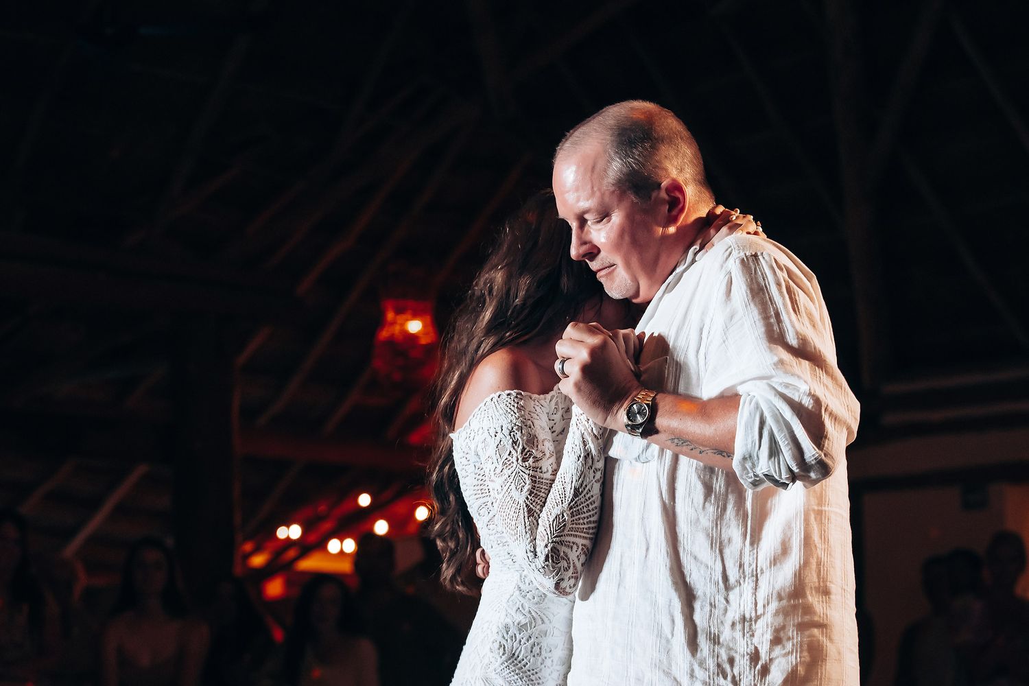 Wedding couple dancing under romantic red lighting at their reception.