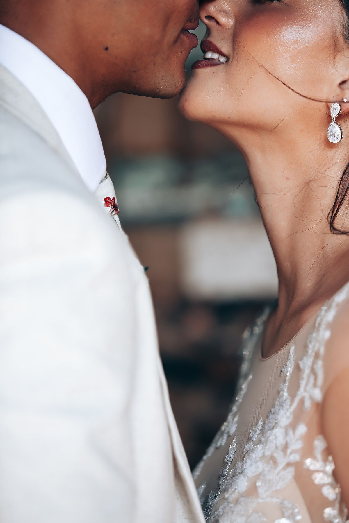 An intimate close-up of a romantic wedding moment showing delicate lace details and jewelry.