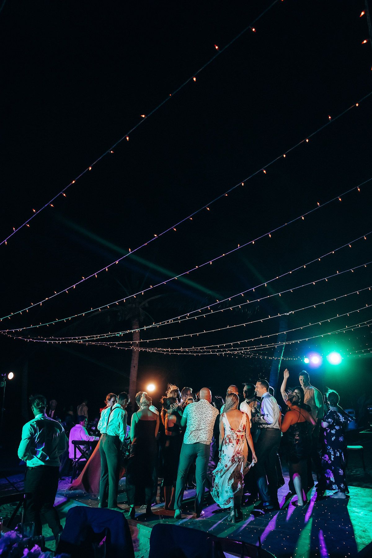String lights create a magical canopy over an evening wedding reception dance floor.