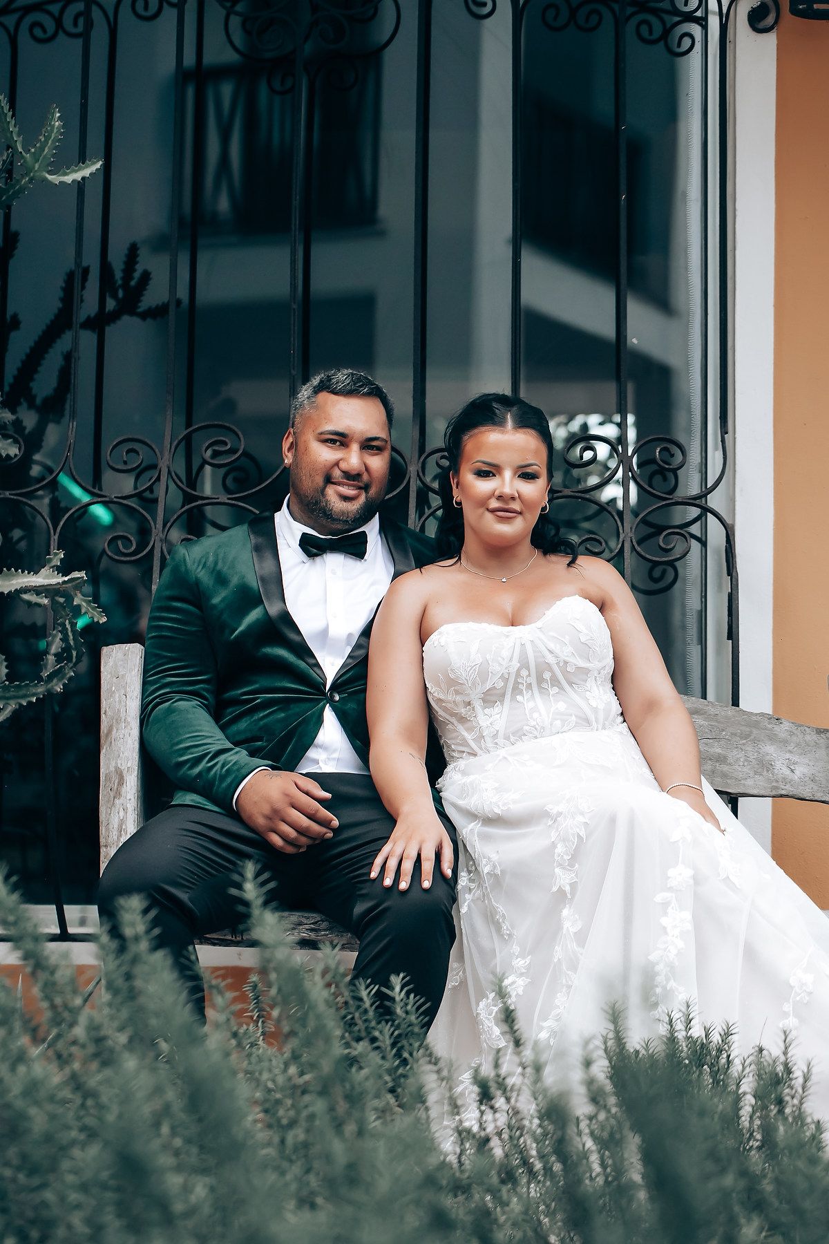 Newlyweds sharing intimate moments on a garden bench surrounded by lavender plants.