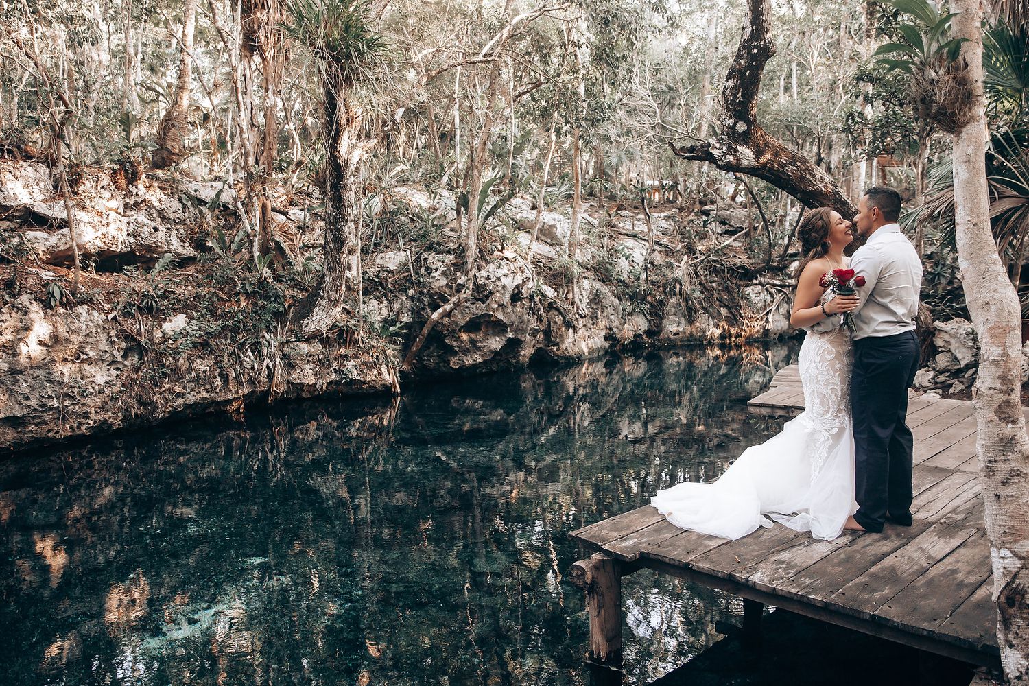 Wedding ceremony reflections shimmer in the still waters of an underground cenote cave.