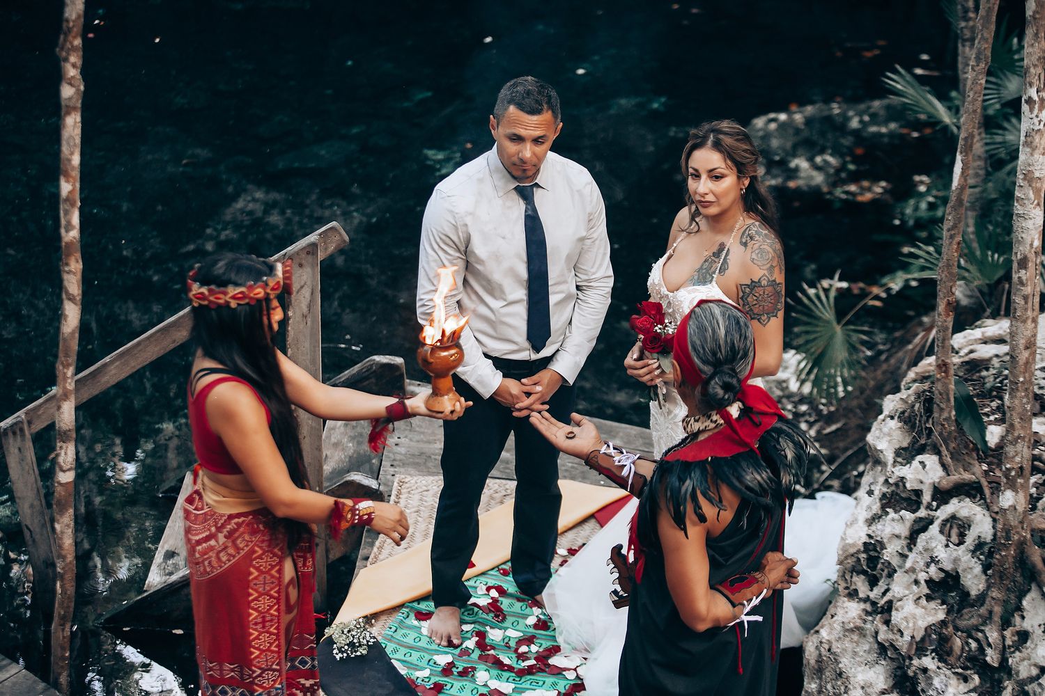 A mystical outdoor wedding ceremony with smoke effects and red accents in a wooded setting.
