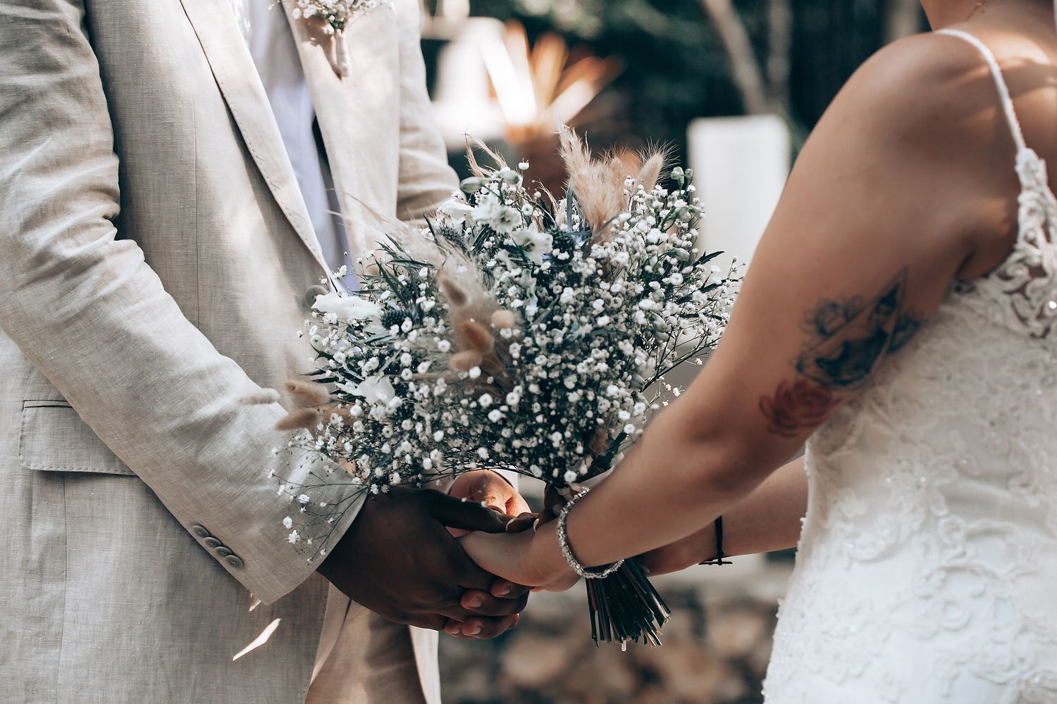 Close-up details of wedding attire and bouquet featuring delicate baby's breath flowers.