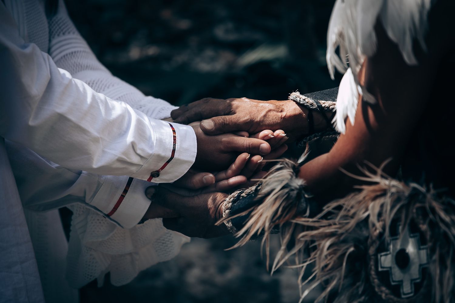 Hands performing ceremonial gestures during a spiritual ritual in a forest.