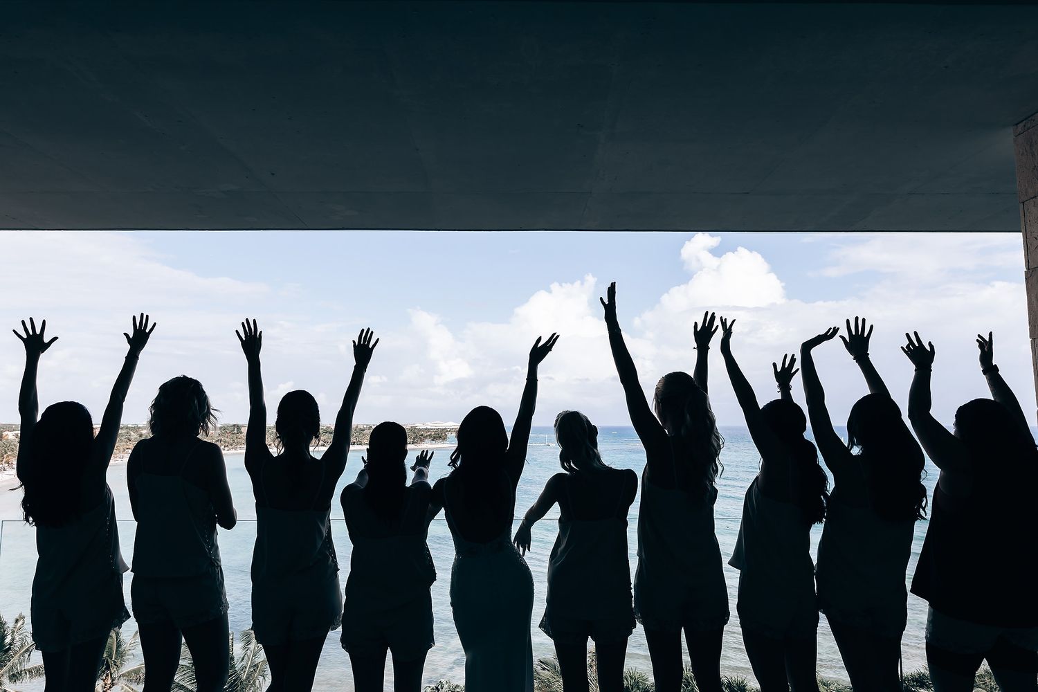 Silhouettes of people with raised arms against a dark sky create a celebratory atmosphere.