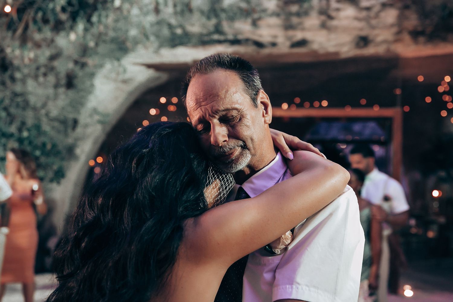 Wedding reception dance floor filled with celebrating guests under string lights.