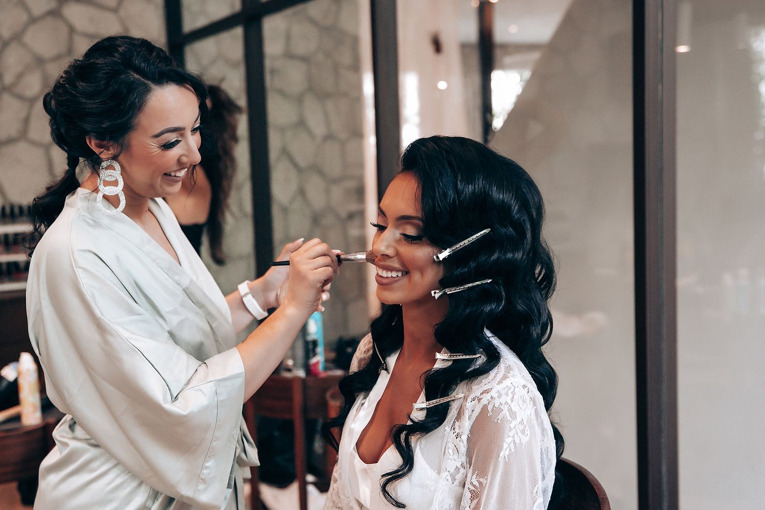 Makeup artist applying cosmetics on a client in a bright studio setting.