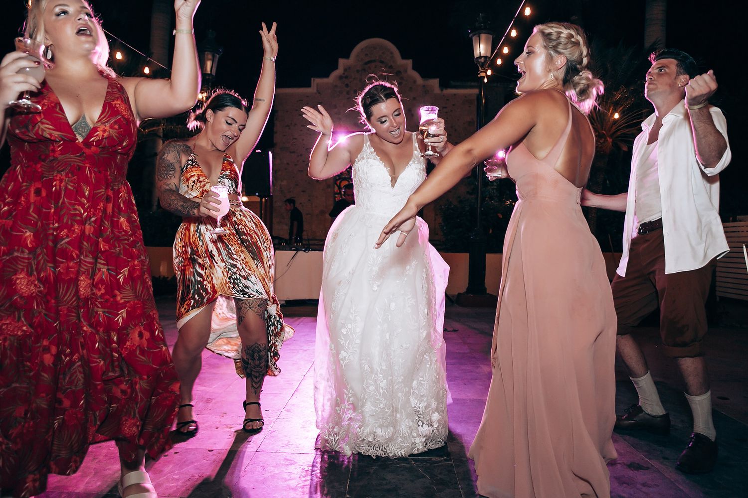 Wedding reception dance party with colorful lighting and festive atmosphere.