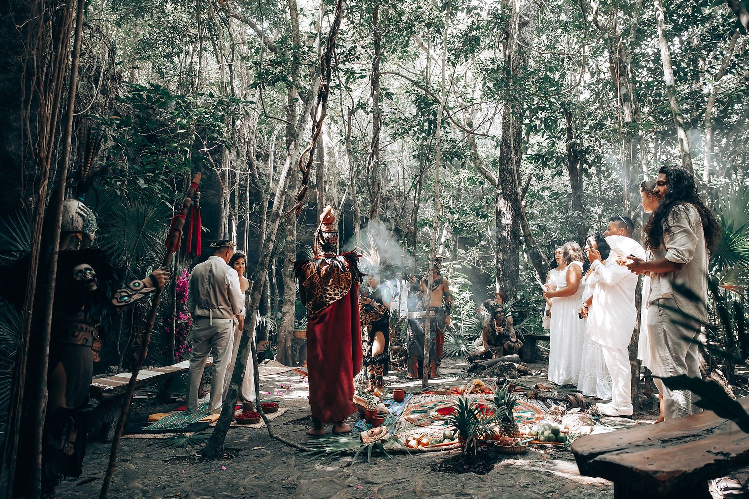 Wedding guests gather in a wooded area for an outdoor ceremony.
