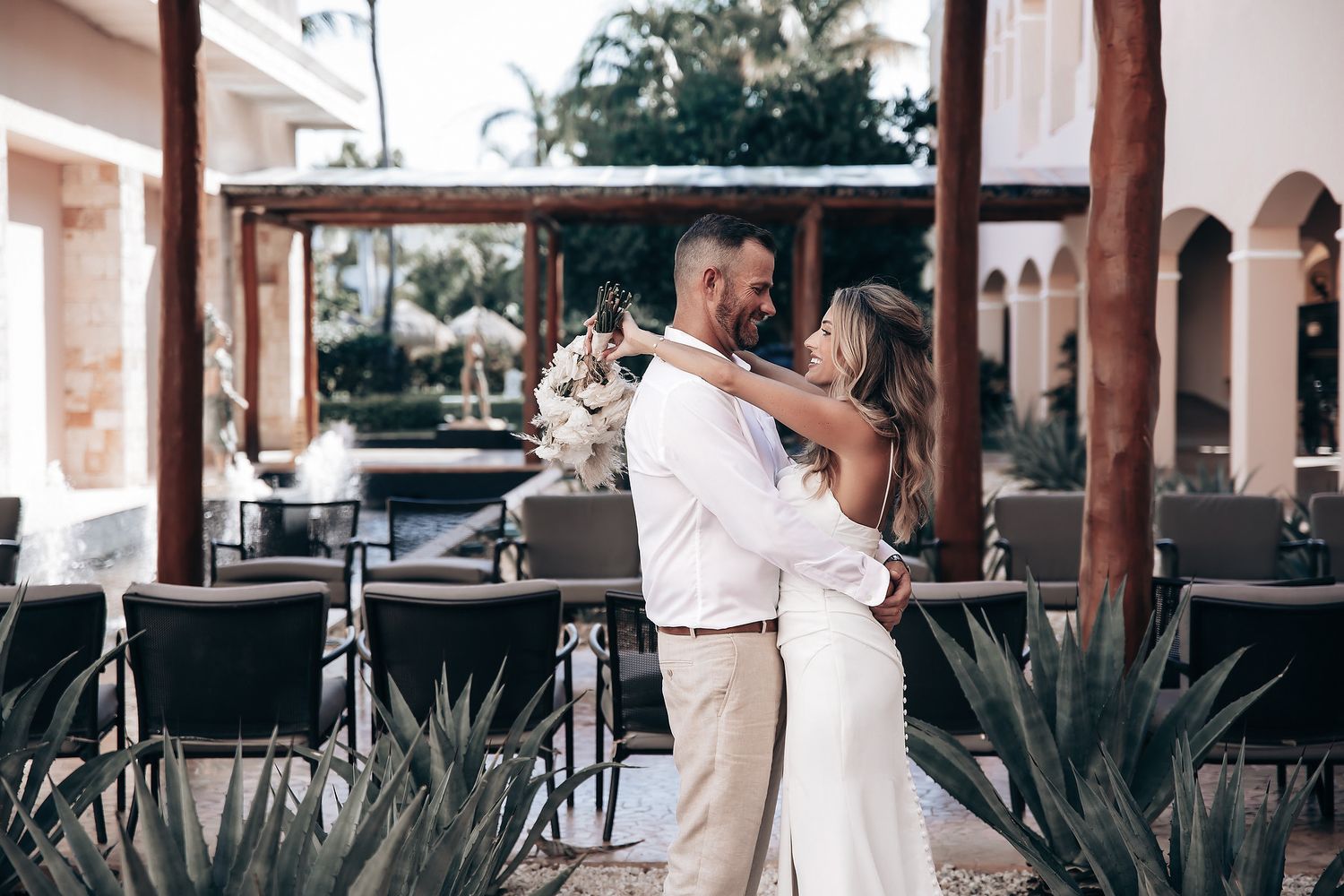 A bride and groom embracing and dancing at what appears to be an outdoor wedding or event.