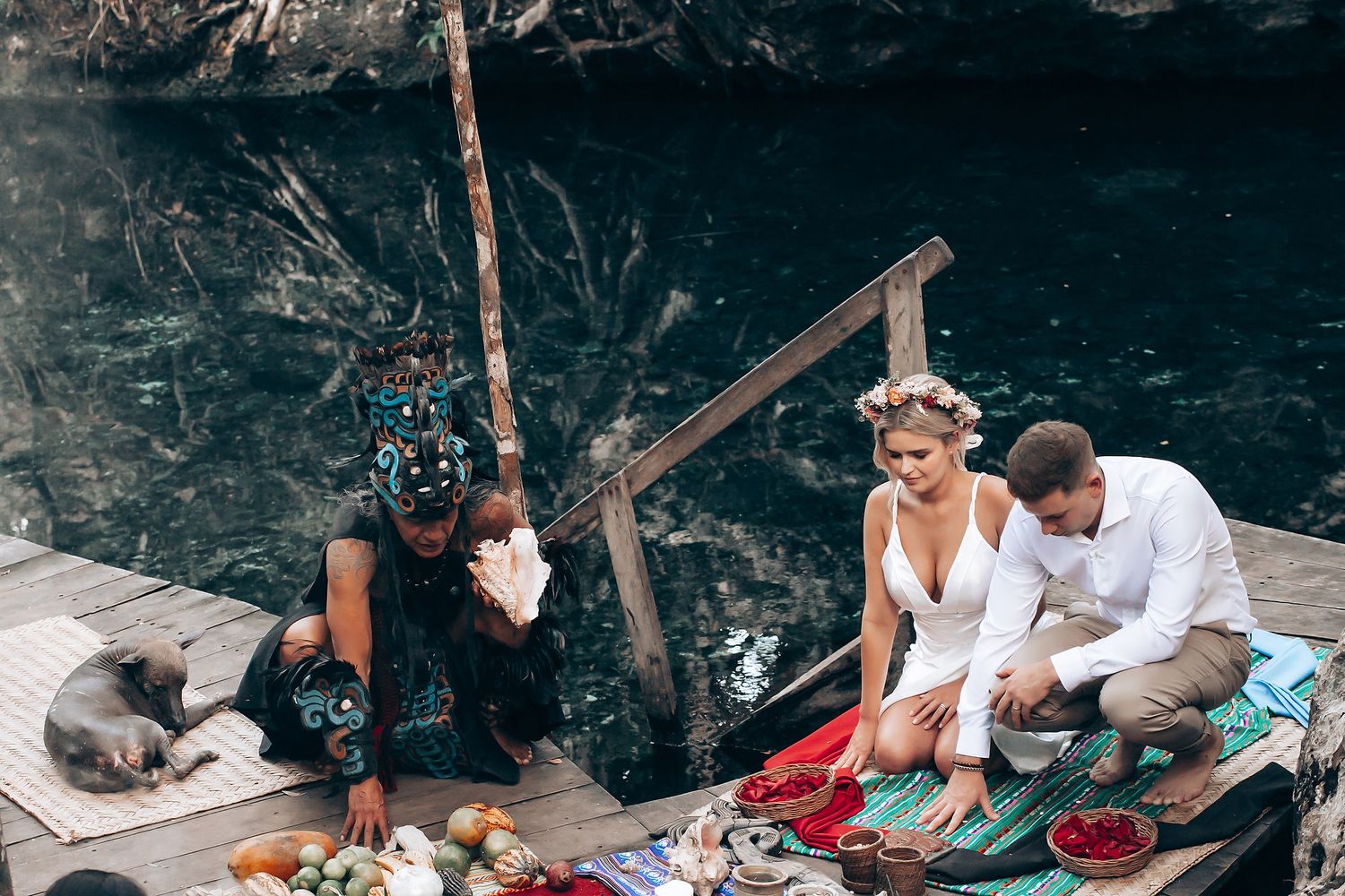 People enjoying a picnic and gathering at the base of a rocky cliff formation on a sunny day.