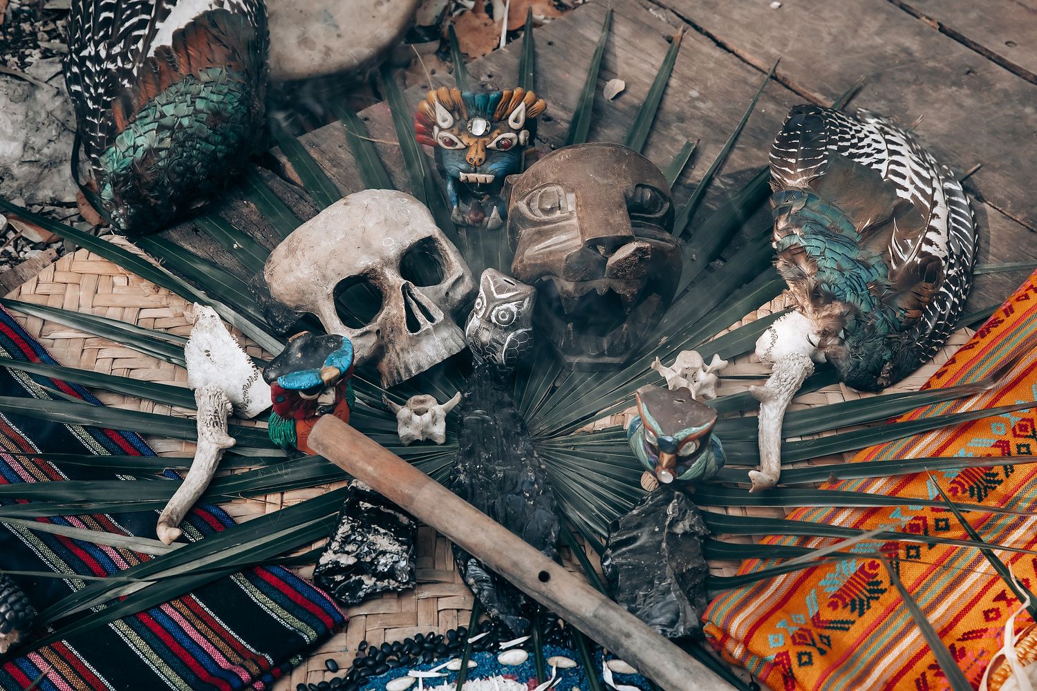 A spooky still life arrangement with a skull, bones, and colorful fabrics in a dark, mystical setting.
