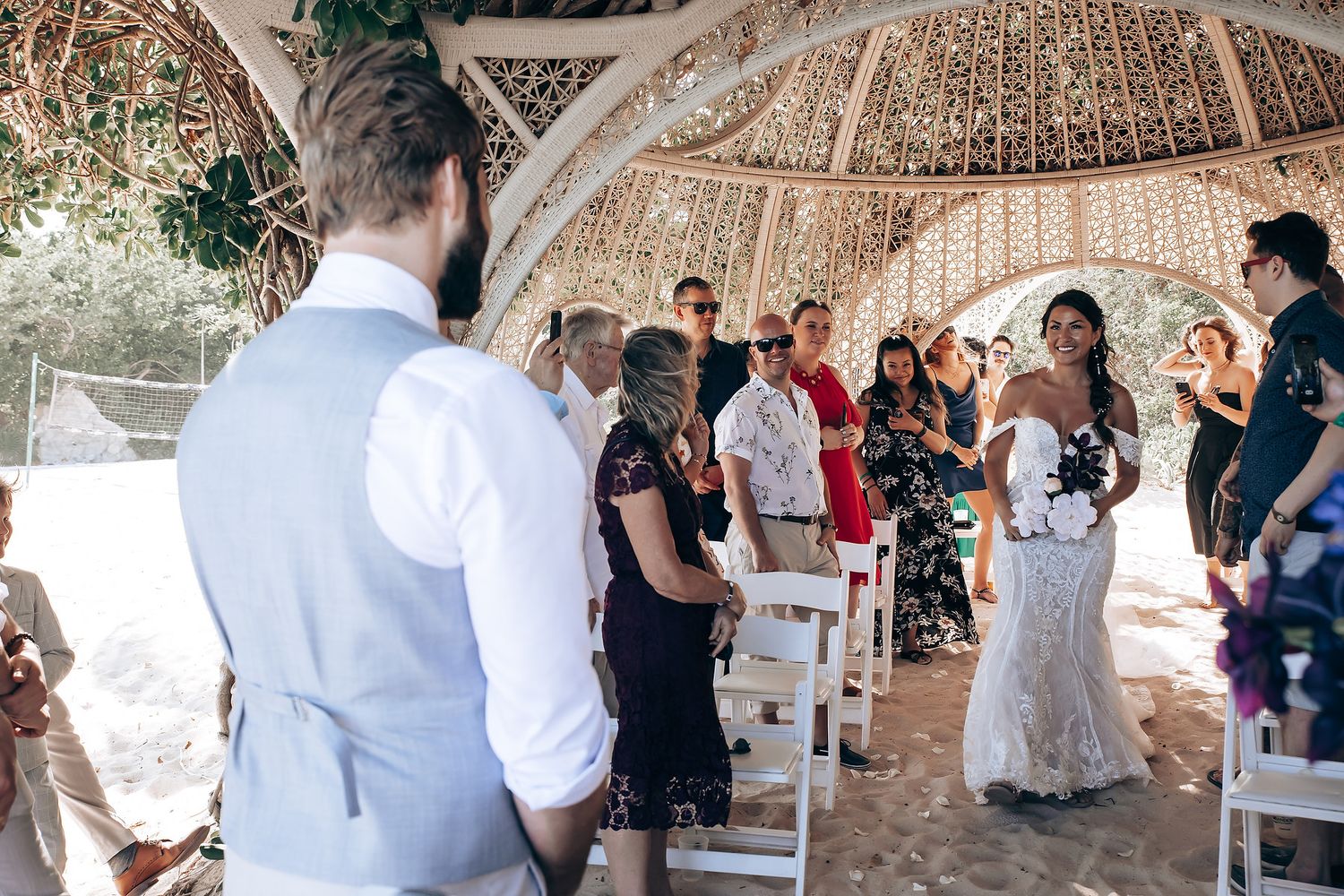 Wedding celebration under arched canopy with guests in attendance.