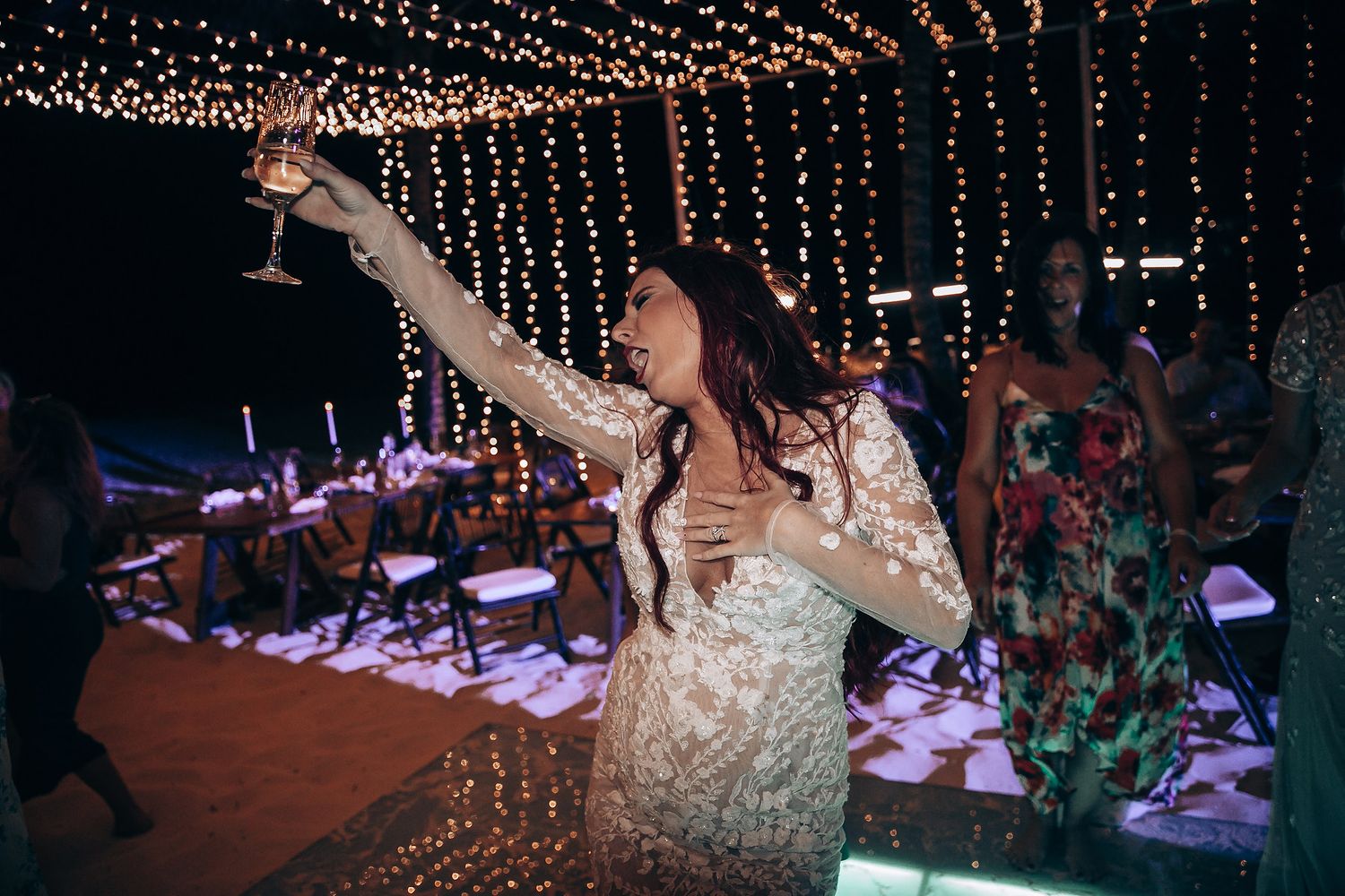 Wedding reception at night with hanging string lights creating magical ambiance.
