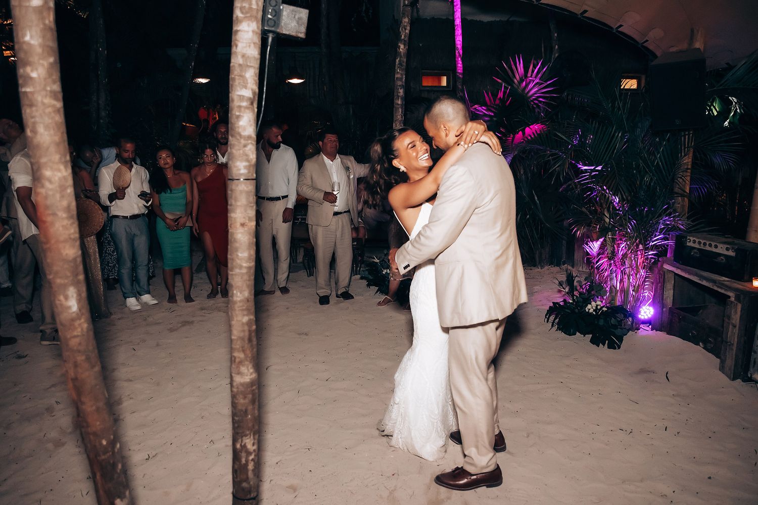 Wedding reception dance floor with purple lighting and tree trunks creating an enchanted atmosphere.