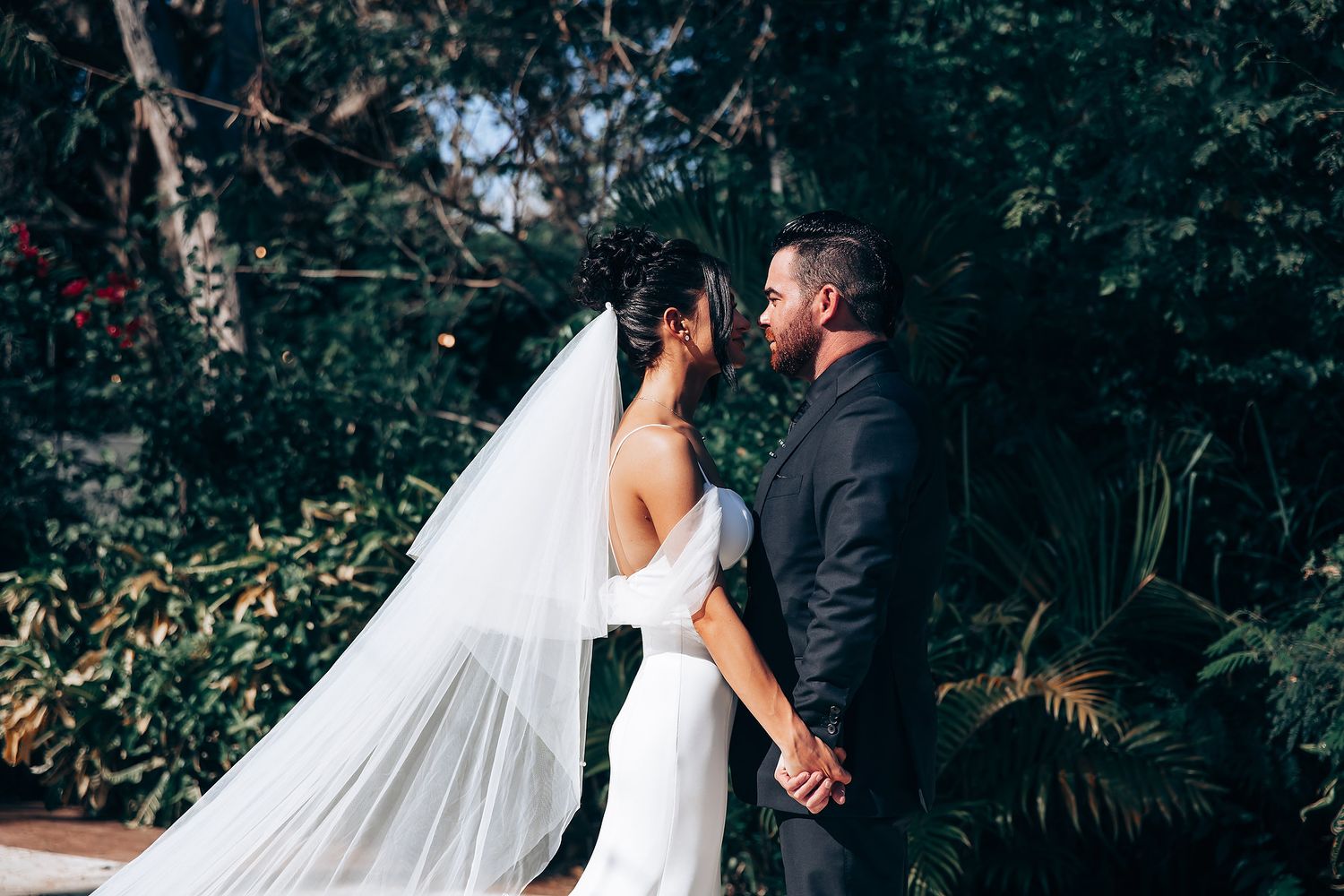 Outdoor wedding portraits with lush garden backdrop and flowing veil.