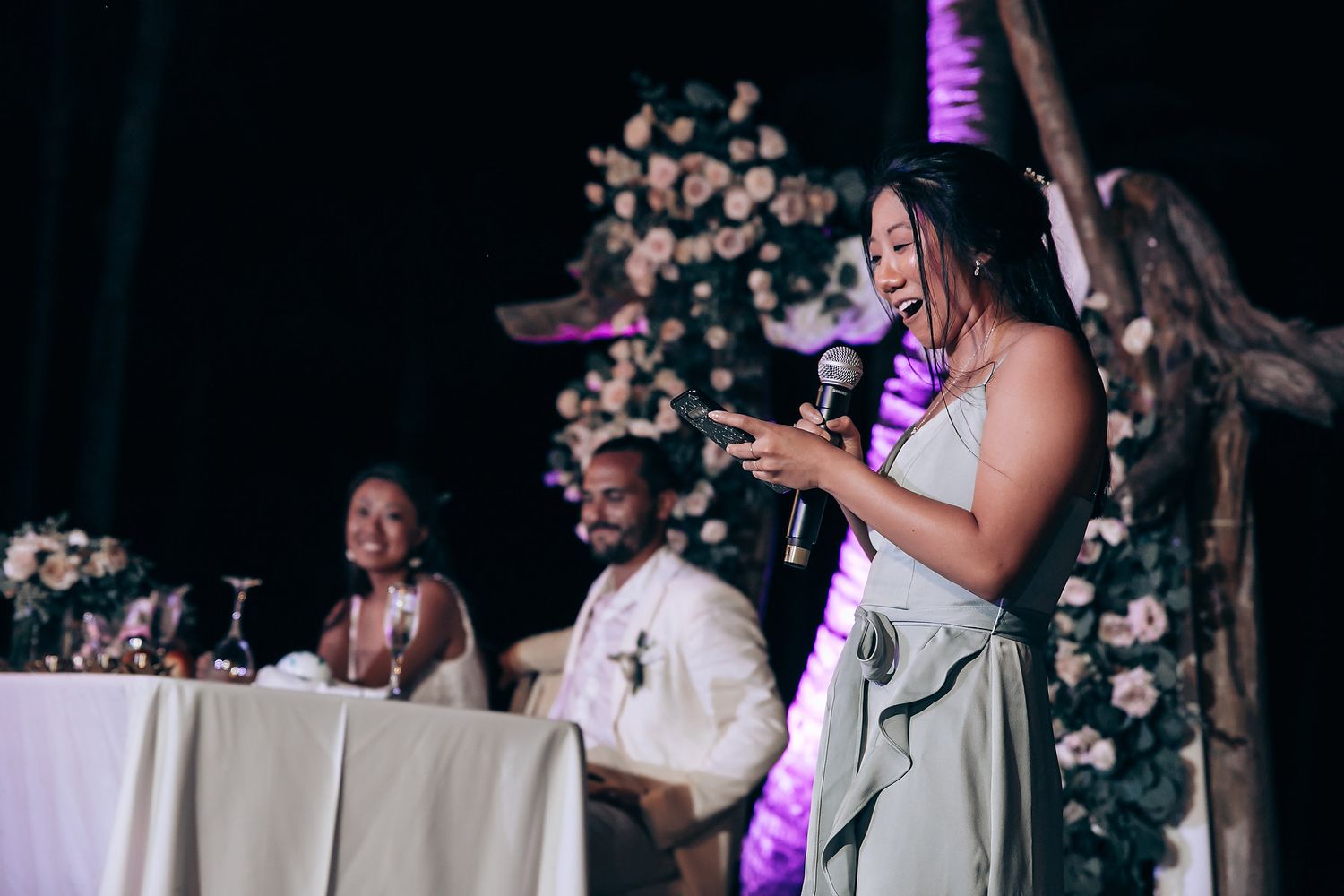 Wedding reception dance party with purple lighting and floral decorations.