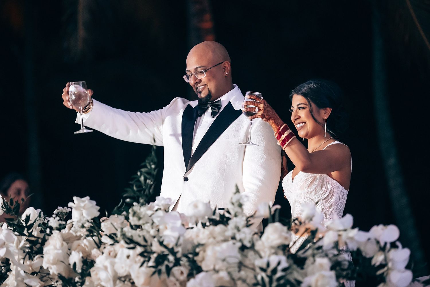 Elegant wedding reception table adorned with white flowers and decorative elements.