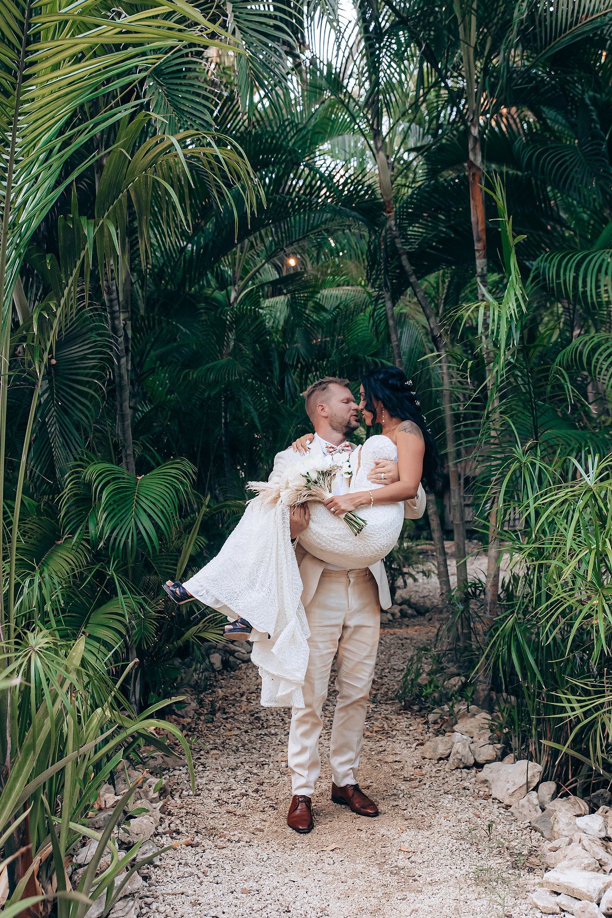 Romantic wedding photo shoot in a lush tropical palm garden with white attire.