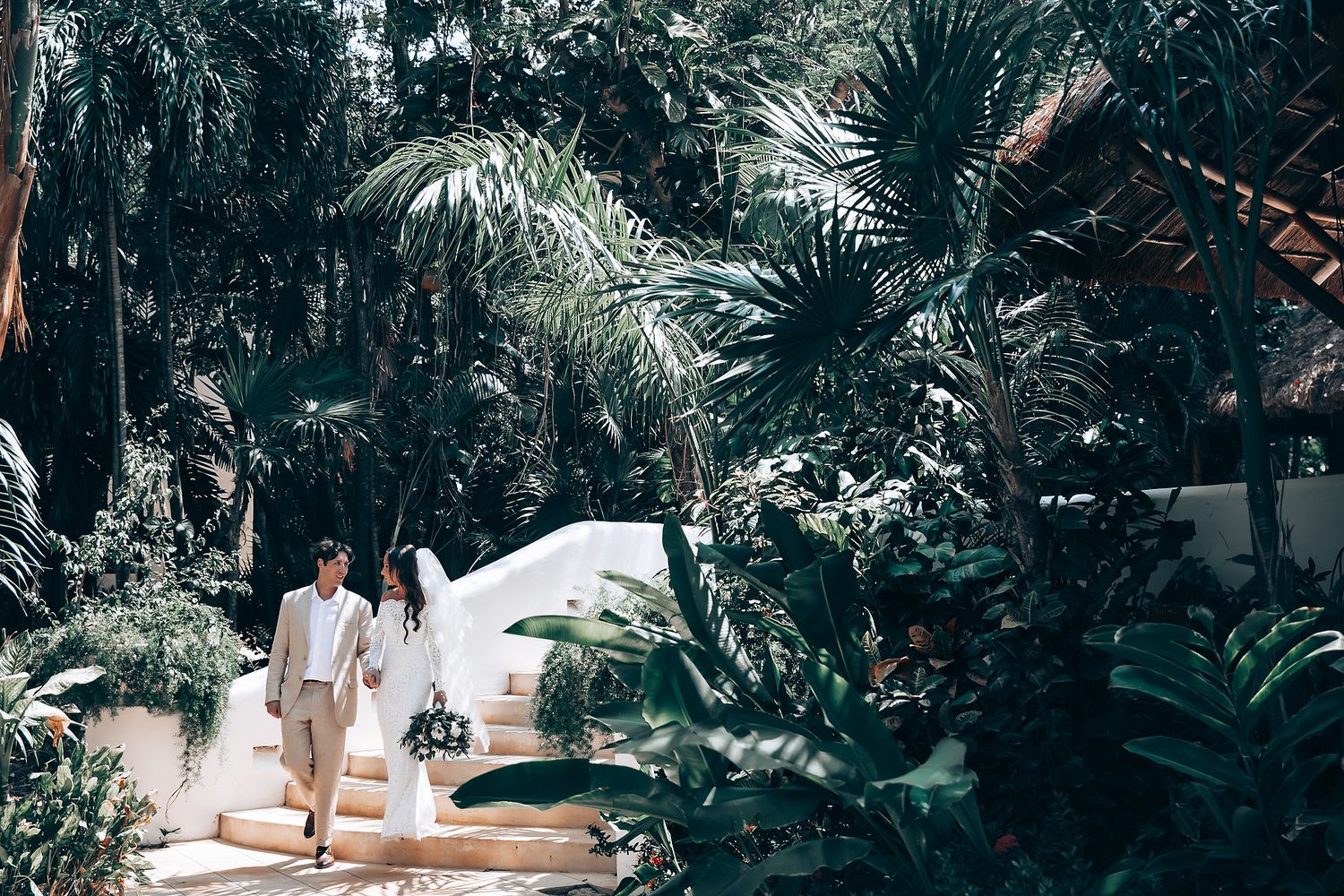 Lush tropical garden setting with palm trees and greenery creating a natural wedding ceremony backdrop.
