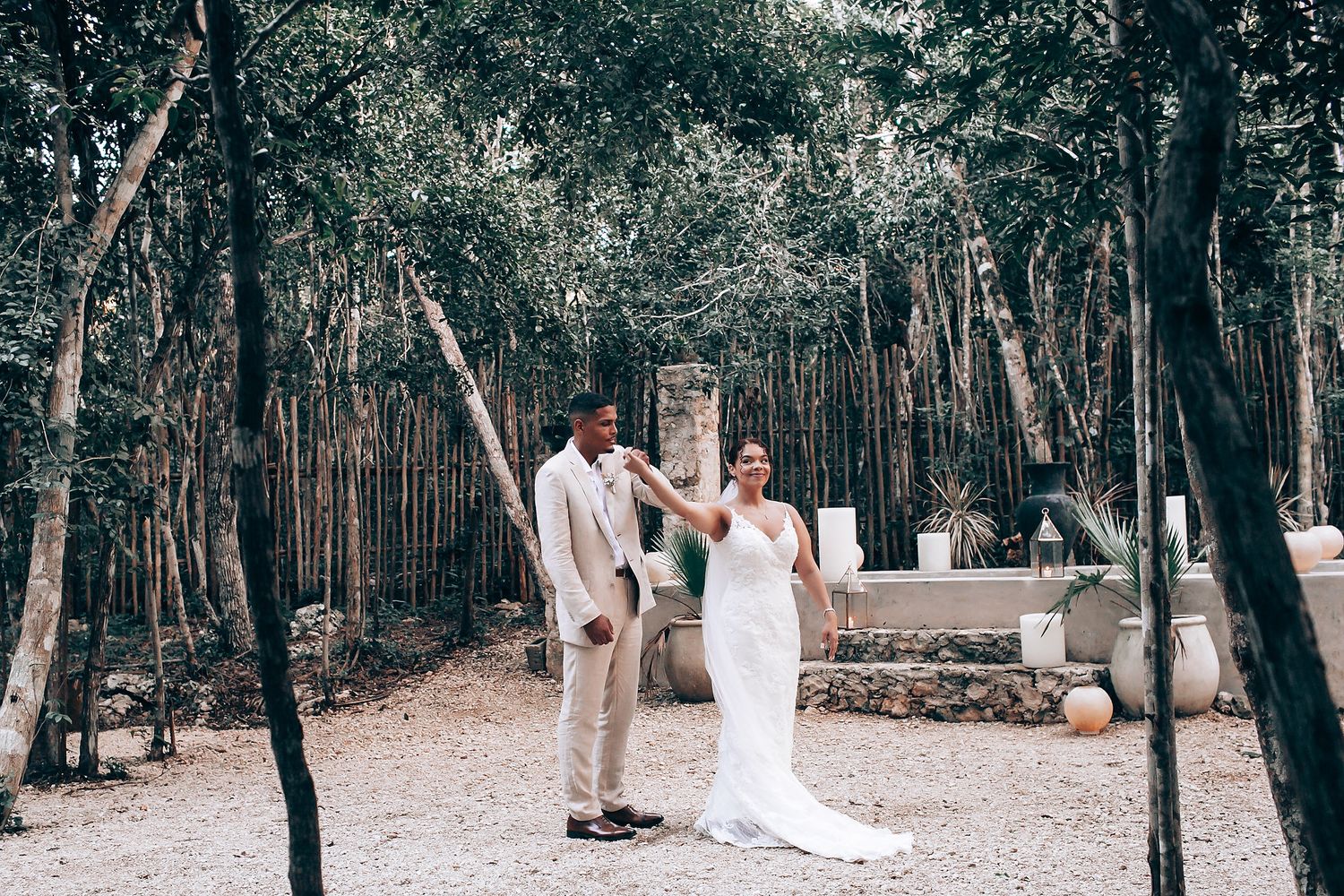 A wedding ceremony in progress along a tree-lined path with natural woodland backdrop.