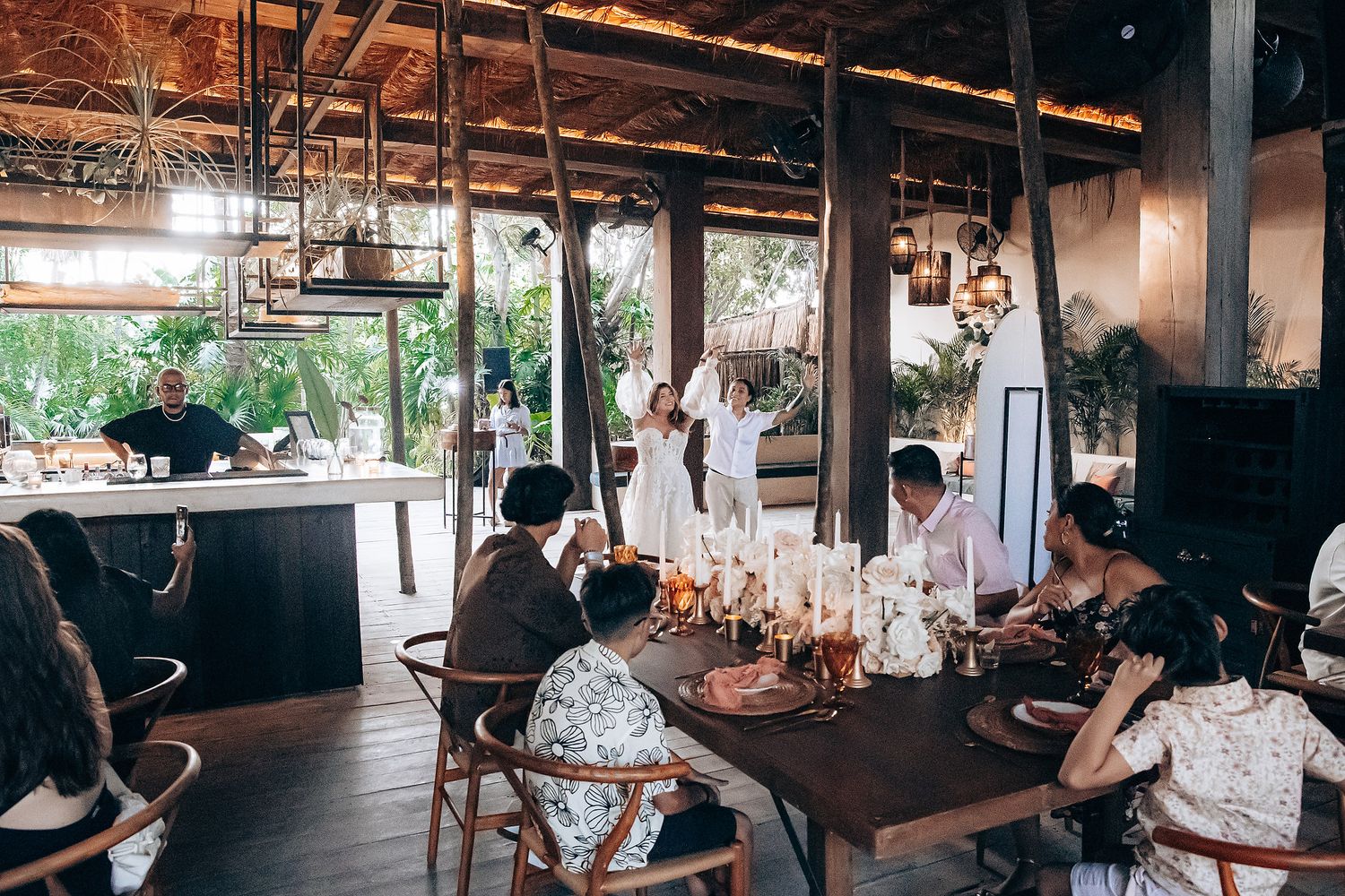 A rustic restaurant interior with exposed wooden beams and pendant lights creates a warm, inviting dining atmosphere.