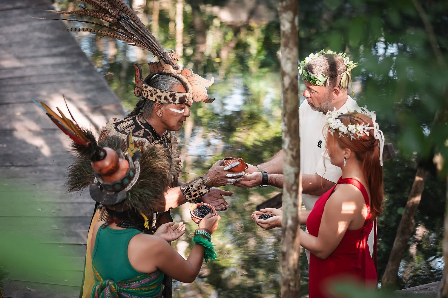 Traditional ritual participants performing sacred gestures in a natural setting.