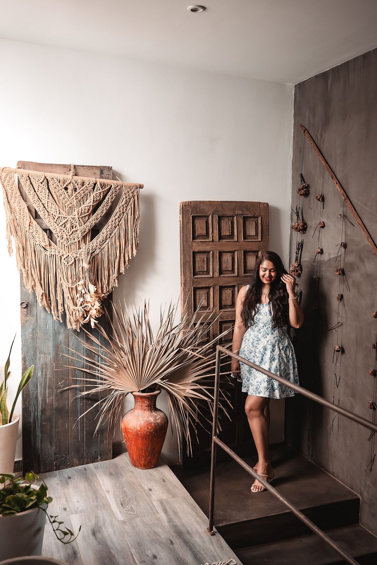 Artistic photo series with dried palm fronds against white wall and wooden door.