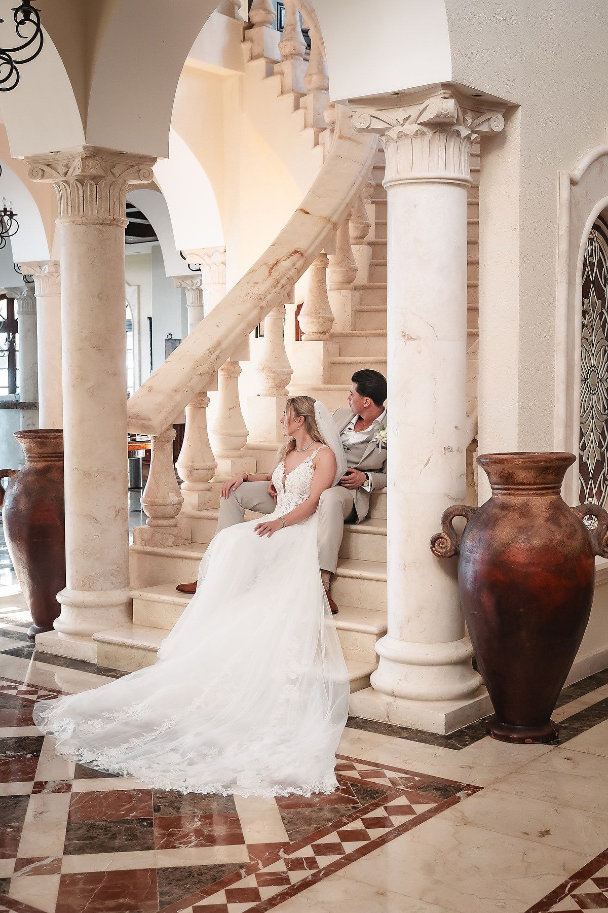 Bridal portraits captured in a Mediterranean-style colonnade with large decorative urns.