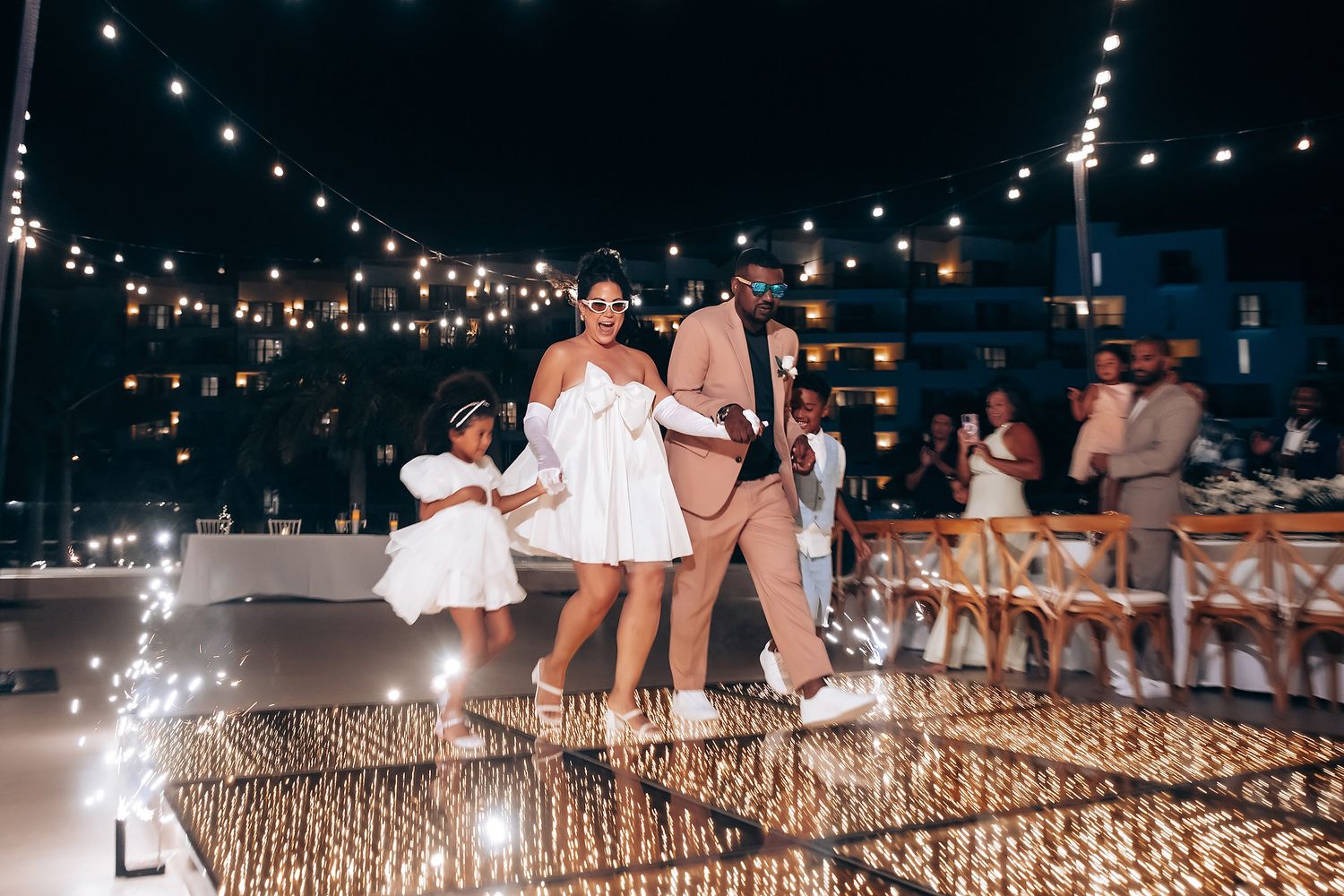 String lights illuminate an outdoor evening celebration setup.