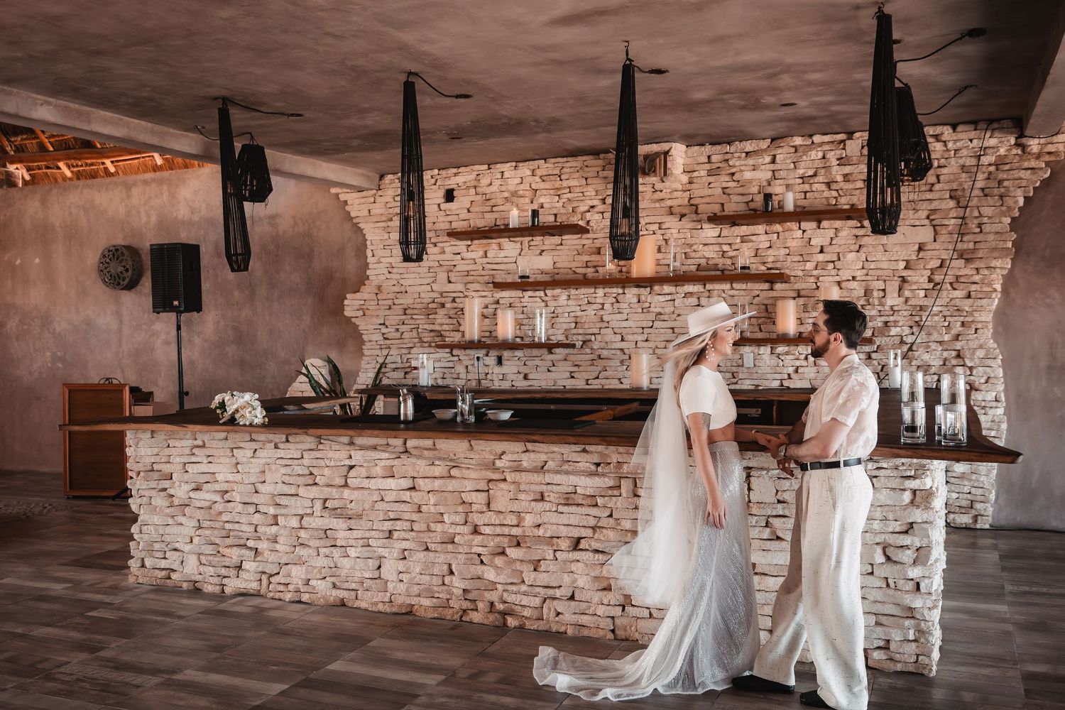 Wedding celebration in an industrial brick venue with hanging pendant lights.
