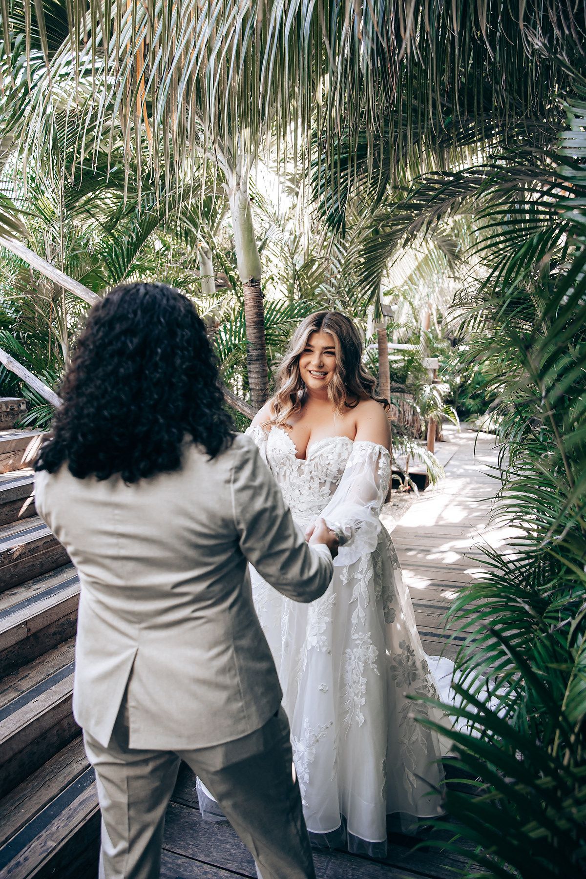 Wedding couple shares intimate moments in a lush garden setting with palm trees.