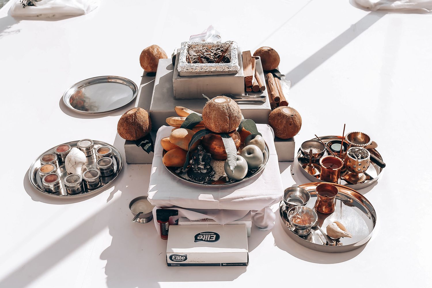 Minimalist flatlay of vintage cameras and decorative items arranged on a white surface with soft lighting.