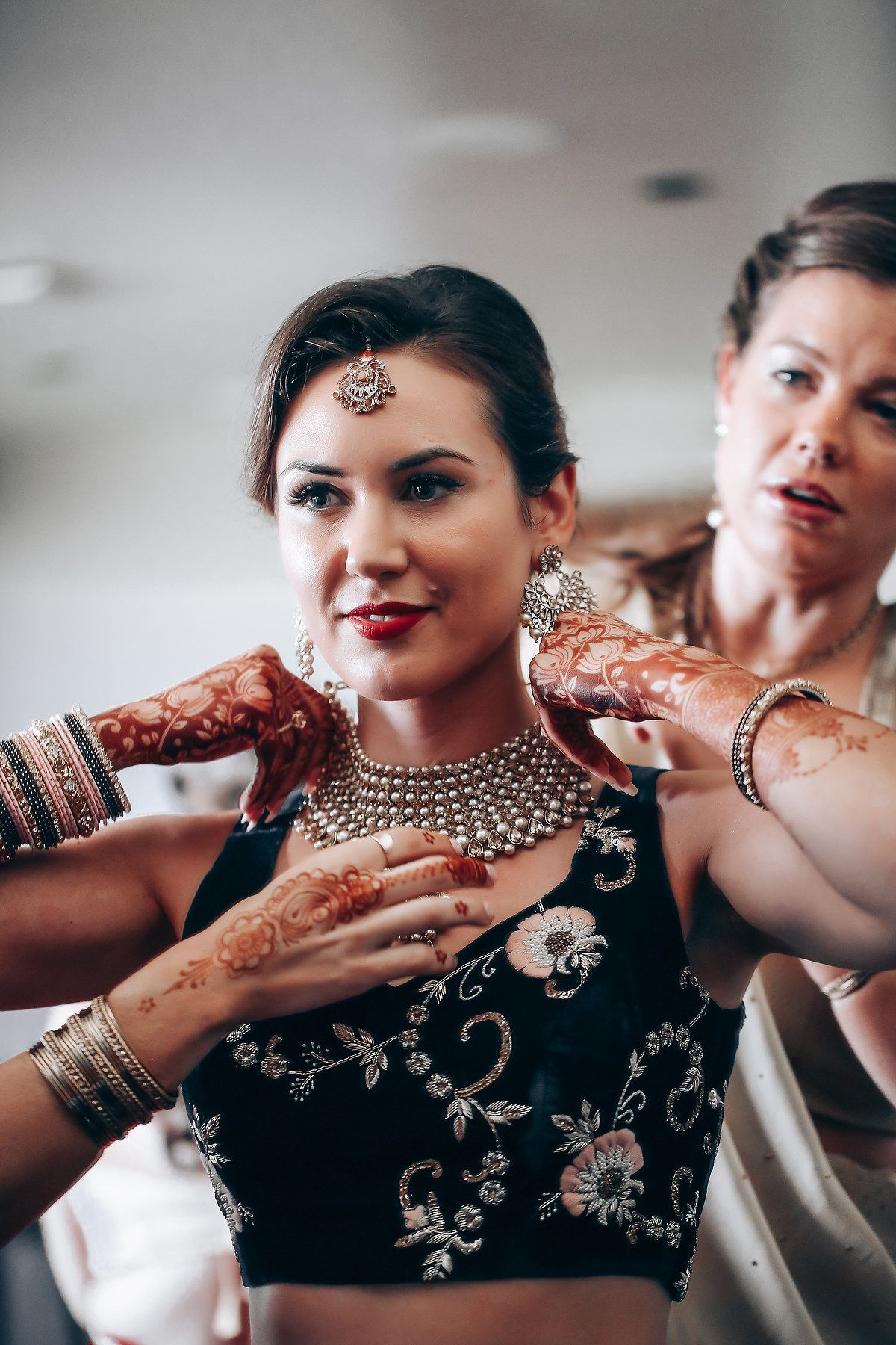 Close-up shots showing intricate bridal jewelry and henna designs during traditional Indian wedding preparations.