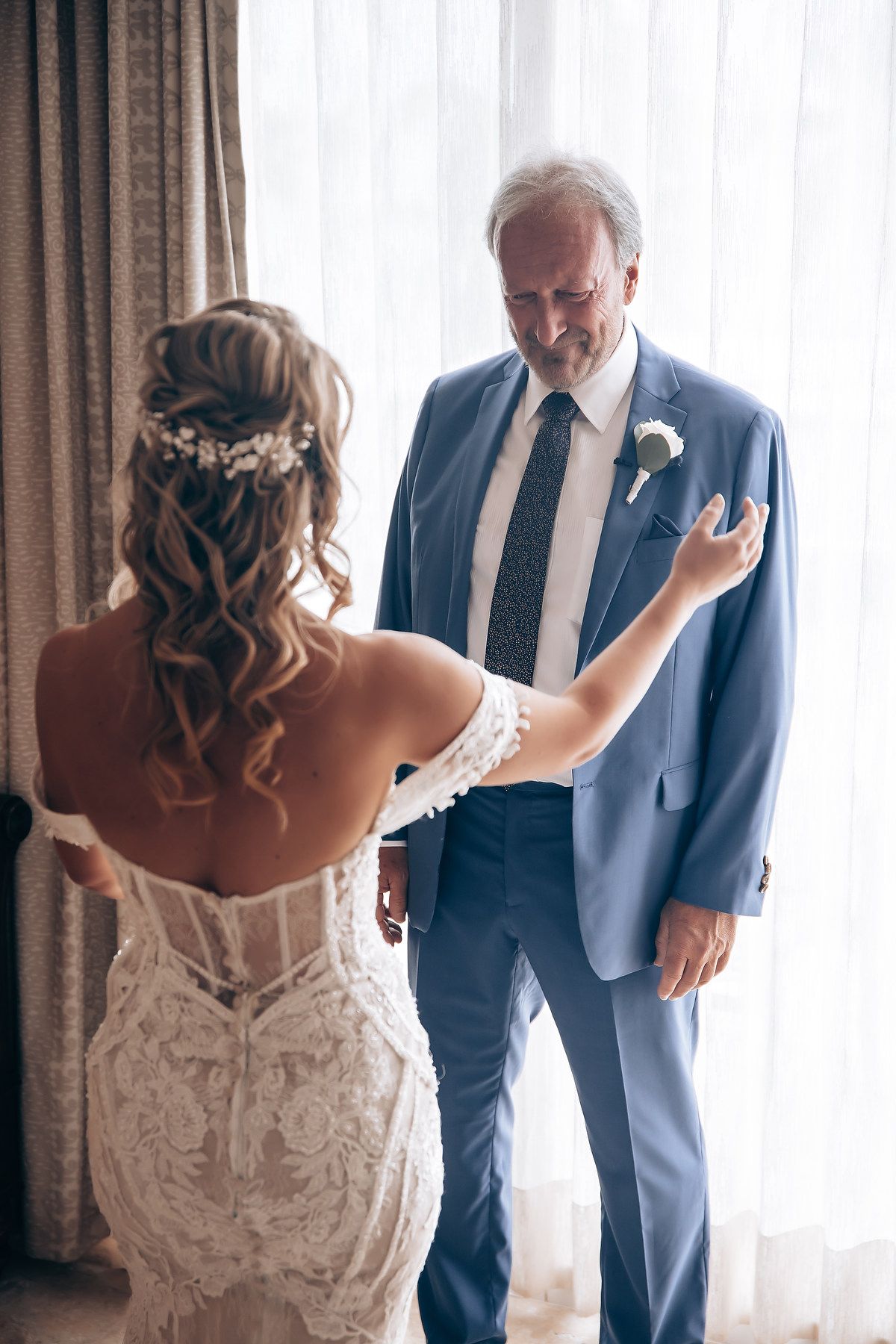 An elegant white lace wedding dress is showcased during a special moment.