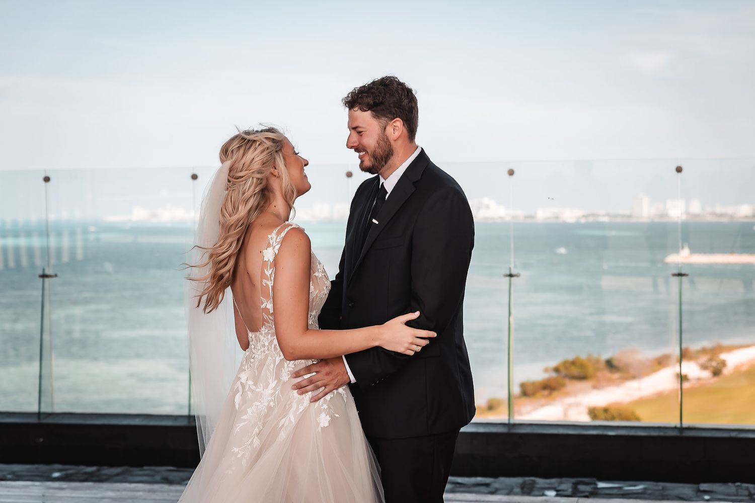 A romantic wedding photoshoot against an oceanfront backdrop on a sunny day.