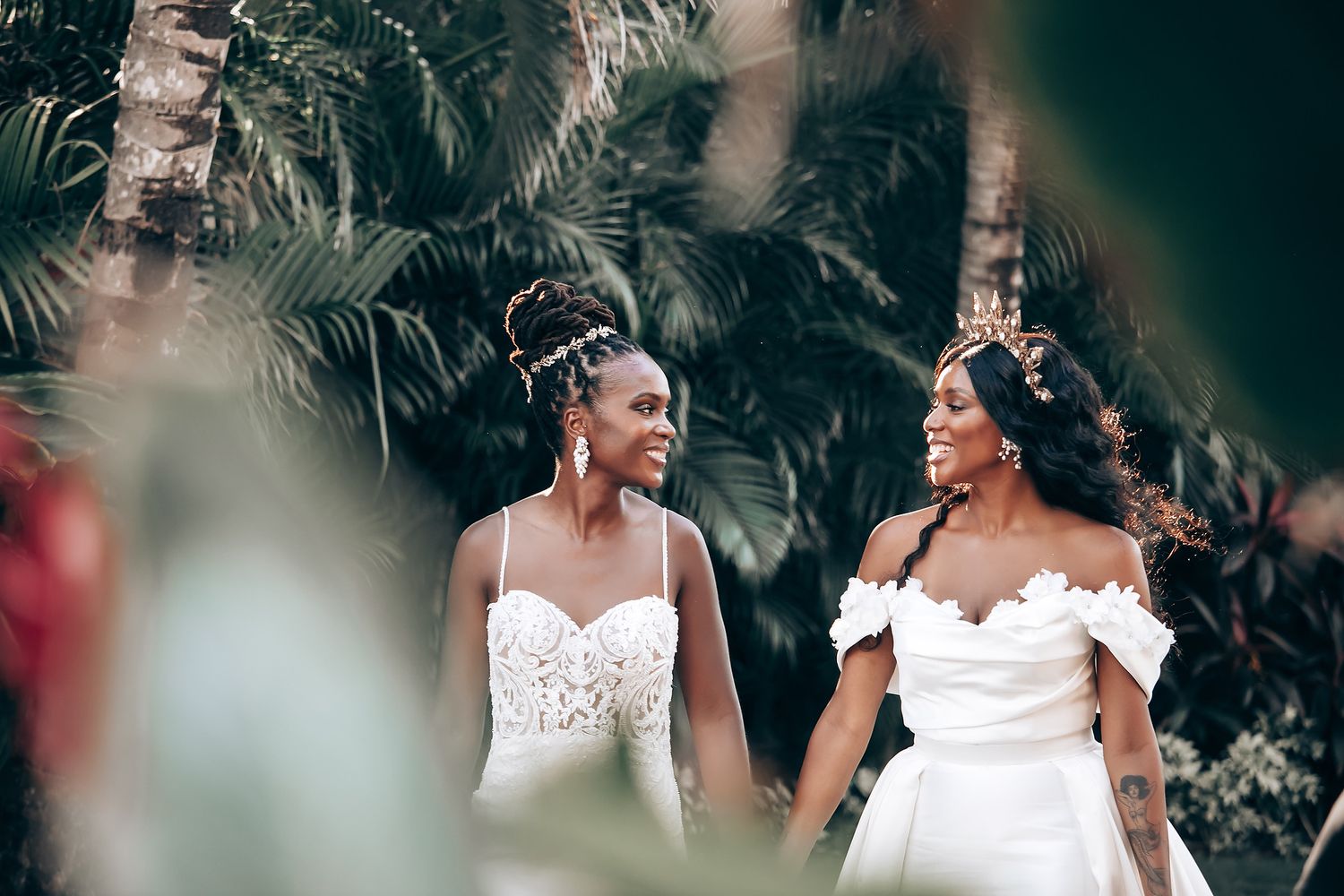A romantic wedding moment captured among palm trees at dusk.
