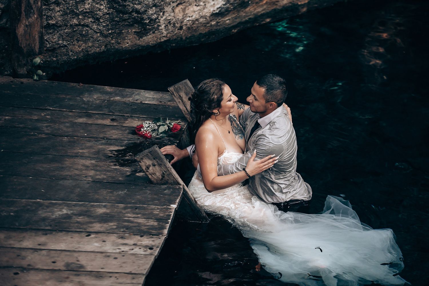 Intimate wedding couple moments captured against dark wooden backdrop in natural setting.