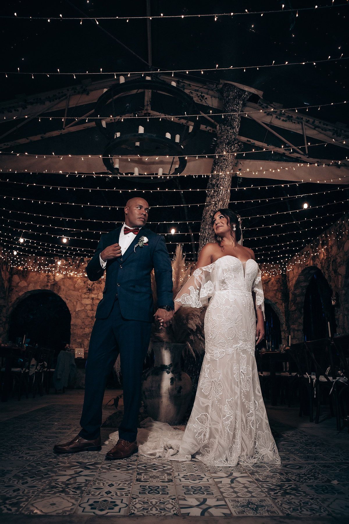 First dance at wedding reception under twinkling string lights.
