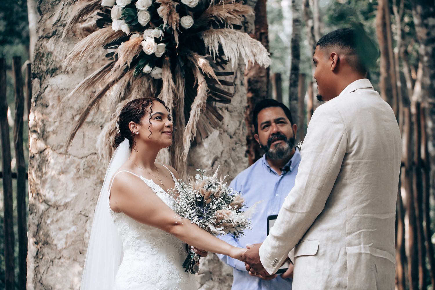 Wedding couple exchanging vows during an outdoor forest ceremony.