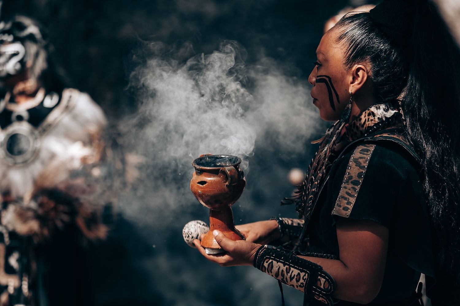 Smoke wafts through the air during an outdoor spiritual ceremony in nature.
