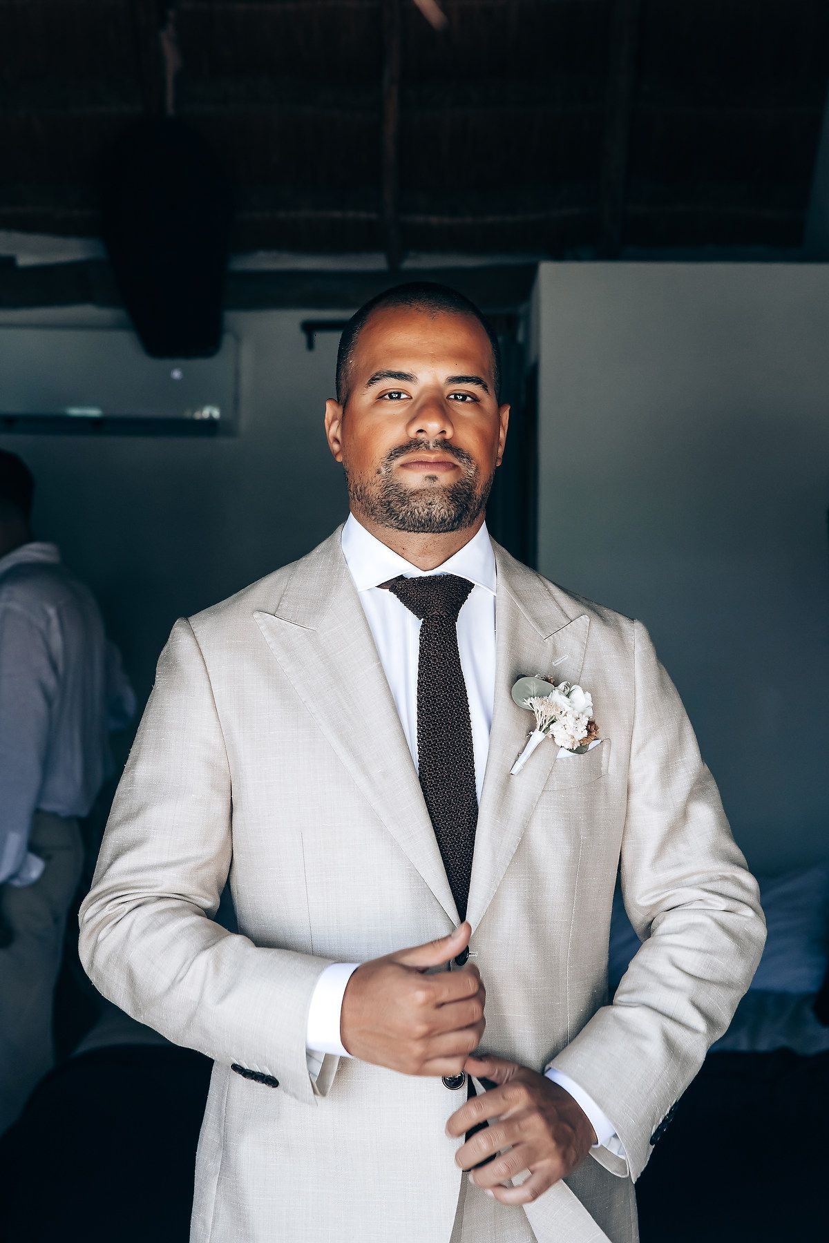 A formal event preparation showing details of a white tuxedo jacket and black tie.