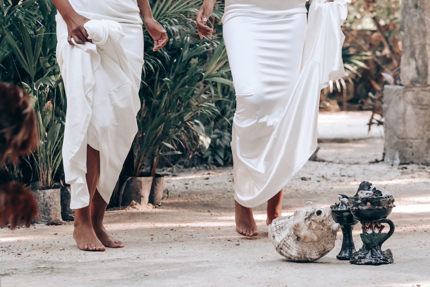 People in white attire gathered for an outdoor ceremony with traditional elements.