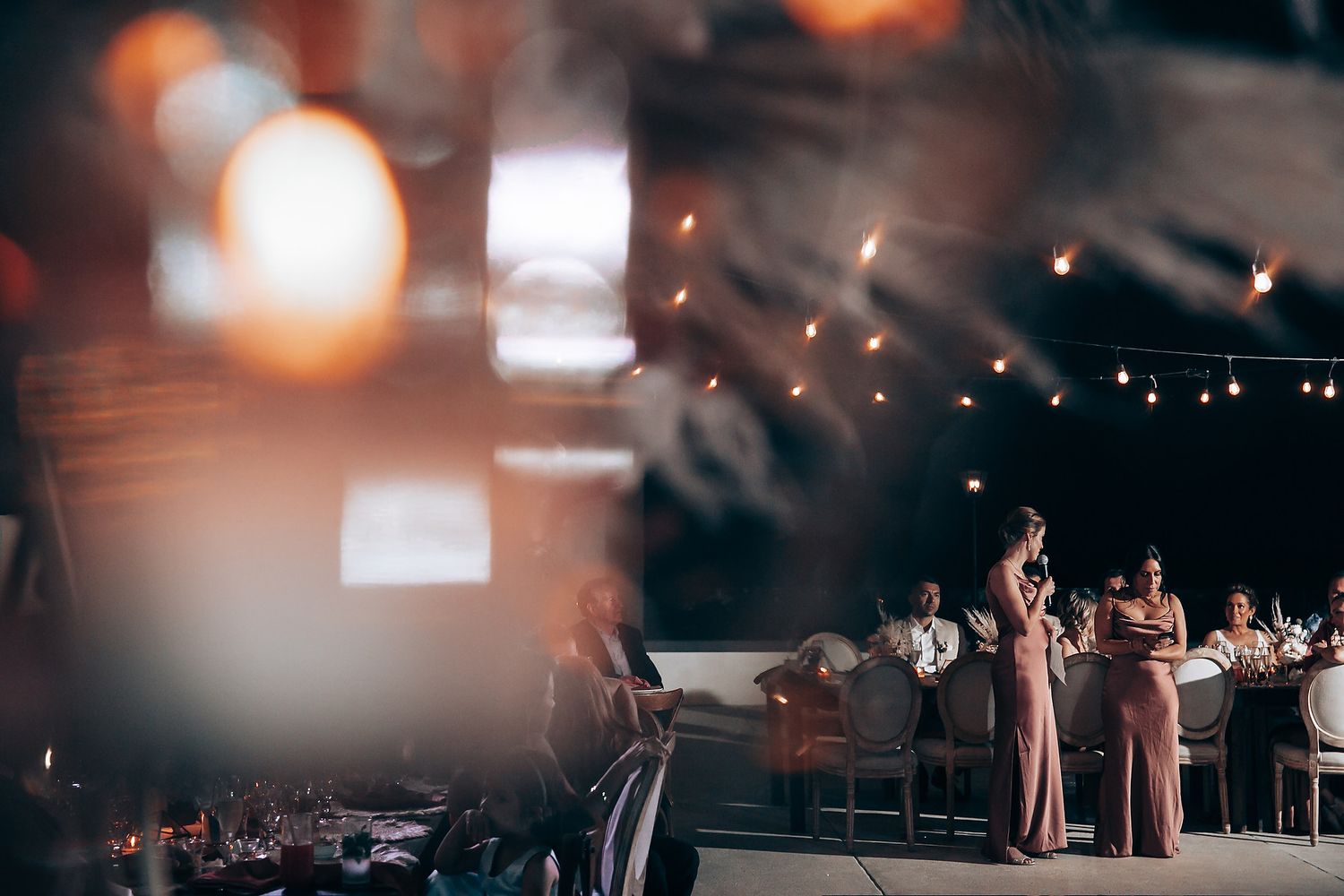 Evening wedding reception with warm lighting and guests celebrating.