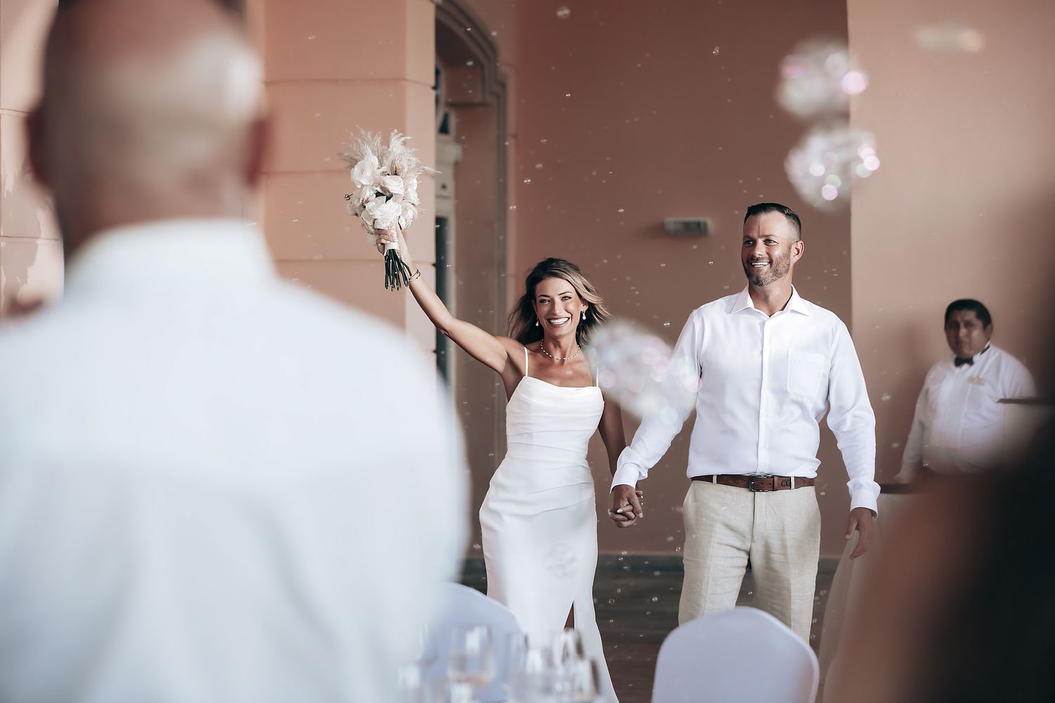 A bride and groom embracing and smiling at what appears to be an outdoor wedding or event.