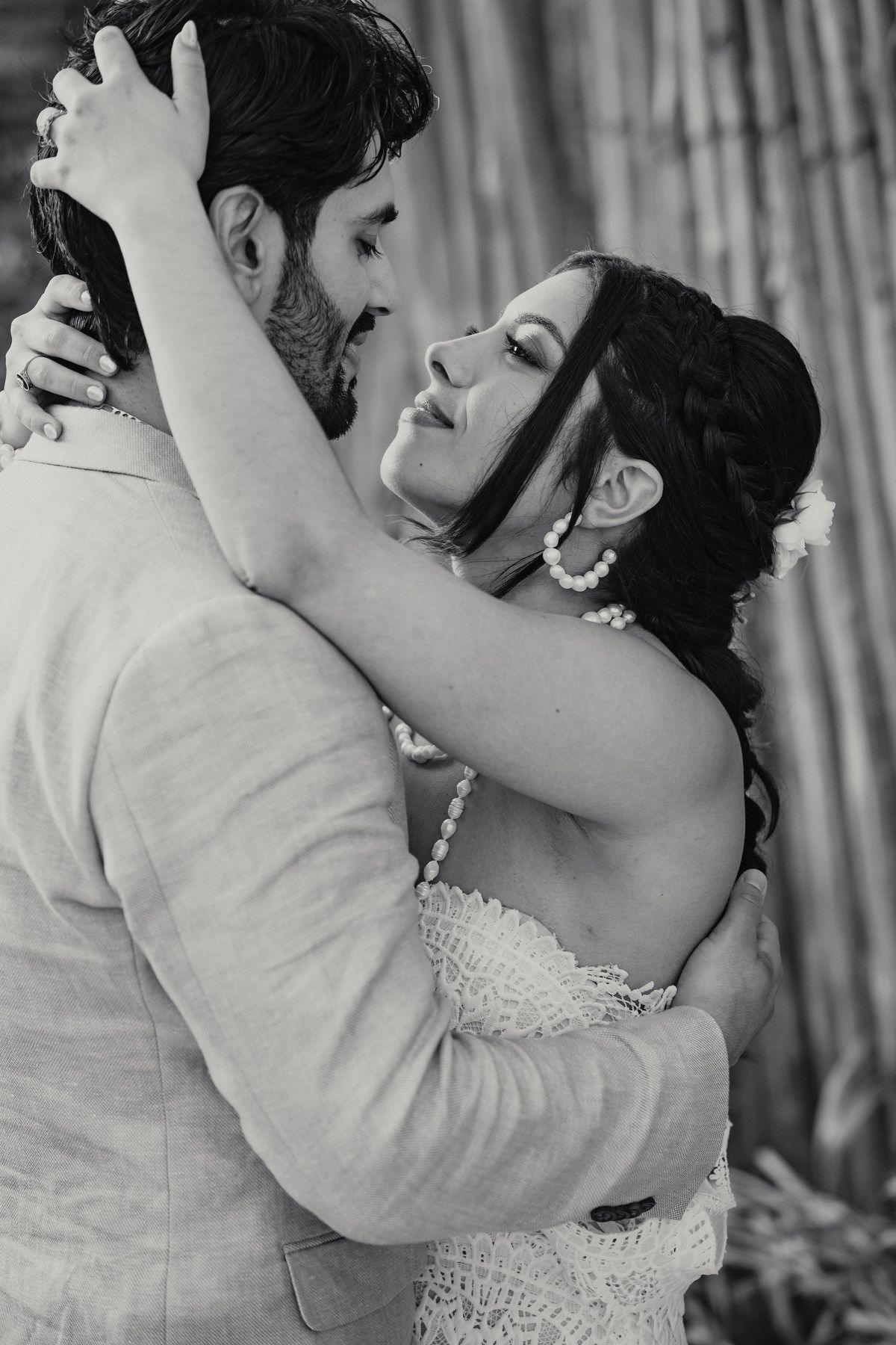 Black and white romantic portrait of bride and groom embracing closely.