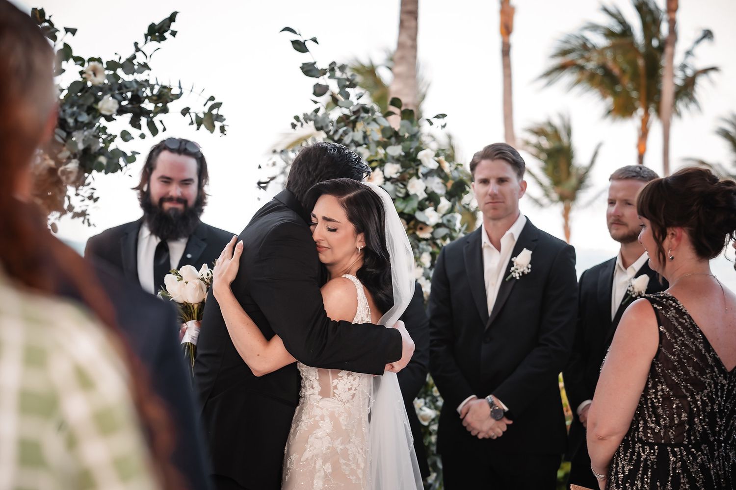 Emotional wedding ceremony moment captured during outdoor tropical celebration.